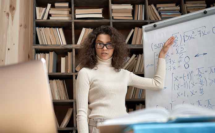 A female teacher on the white board teaching her online Master of Computer Science class.