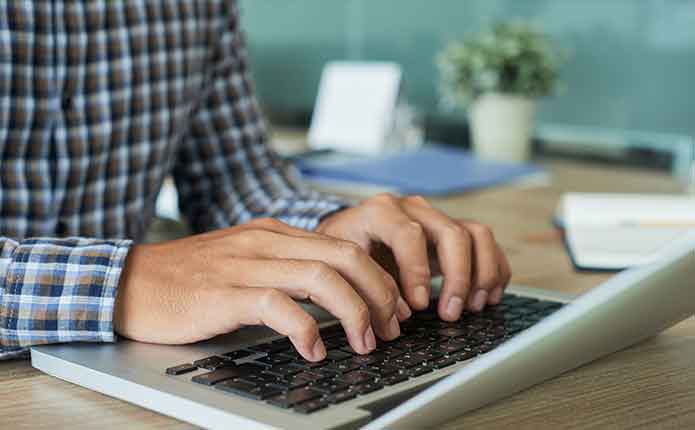 A student on the computer working on a project for the online Master of Computer Science class.