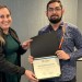 Woman presents ICRC Best Poster Award certificate to Rice CS PhD student David Quiroga